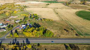 Aerial view of property and surrounding area featuring rural landscape and farmland