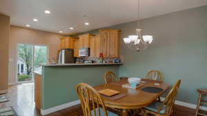 Dining area featuring a chandelier, dark wood-style flooring, and recessed lighting