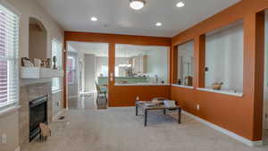 Carpeted living room with a fireplace, recessed lighting, and a chandelier