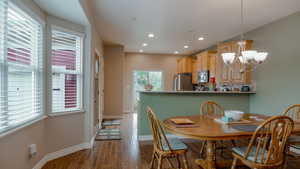 Dining space featuring dark wood-type flooring, a chandelier, and recessed lighting