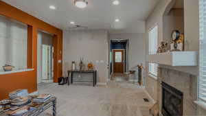 Living area featuring carpet flooring, a tile fireplace, and recessed lighting