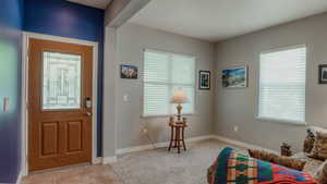Foyer with light tile patterned flooring and baseboards