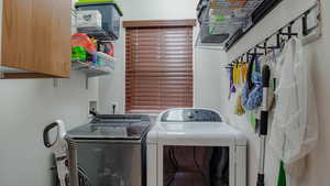Washroom featuring cabinet space and washer and clothes dryer