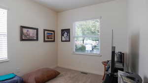 Living area featuring light colored carpet and baseboards