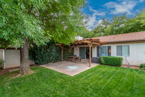 Rear view of property with a pergola, a lawn, a patio, and a tiled roof