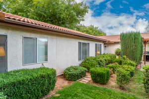 View of side of property featuring stucco siding and a tiled roof