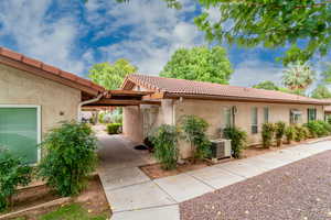 View of front of house with stucco siding and a tile roof