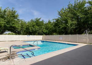 Community pool featuring a community hot tub and a patio area