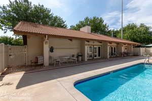 Rear view of property featuring french doors, a patio, a chimney, a tile roof, and stucco siding