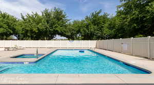 Community pool featuring a patio and a hot tub