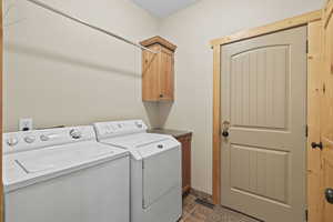 Laundry room with independent washer and dryer and cabinet space