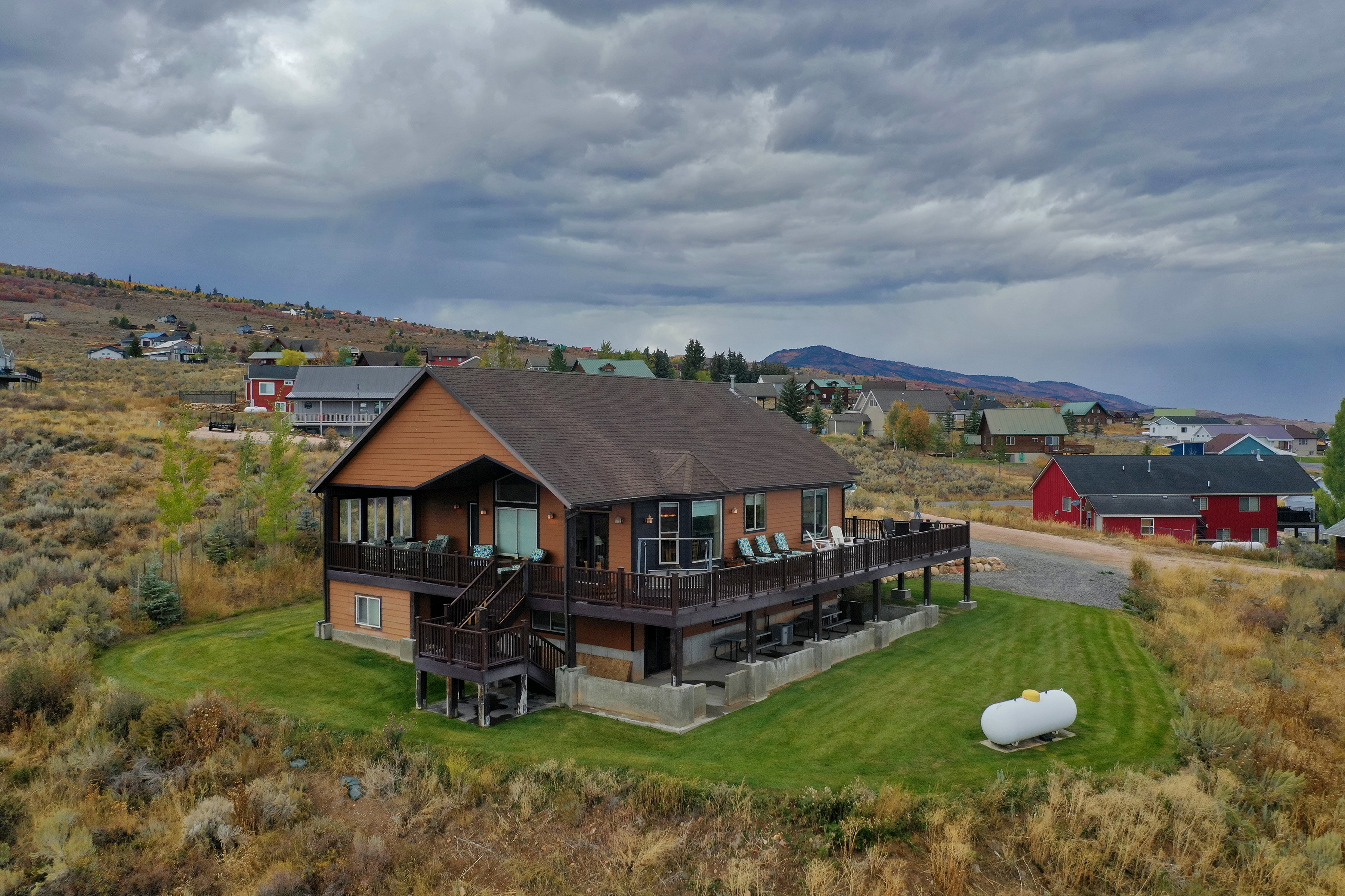 Rear view of house with a deck with mountain view and a lawn