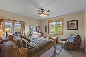 Bedroom featuring access to exterior, a ceiling fan, and a textured ceiling