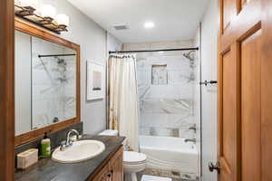 Full bathroom featuring shower / bath combination with curtain, vanity, and a textured ceiling