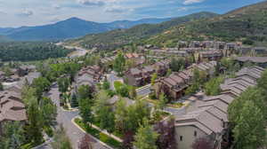 Aerial view of property and surrounding area with a mountain backdrop and nearby suburban area
