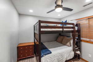 Bedroom with a textured ceiling, light wood-style flooring, a ceiling fan, and recessed lighting