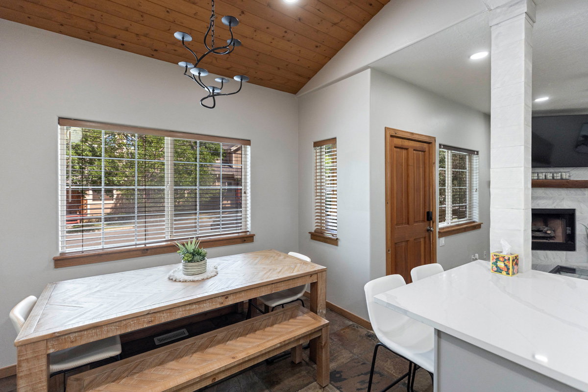 Dining room featuring vaulted ceiling, healthy amount of natural light, wood ceiling, a fireplace, and recessed lighting