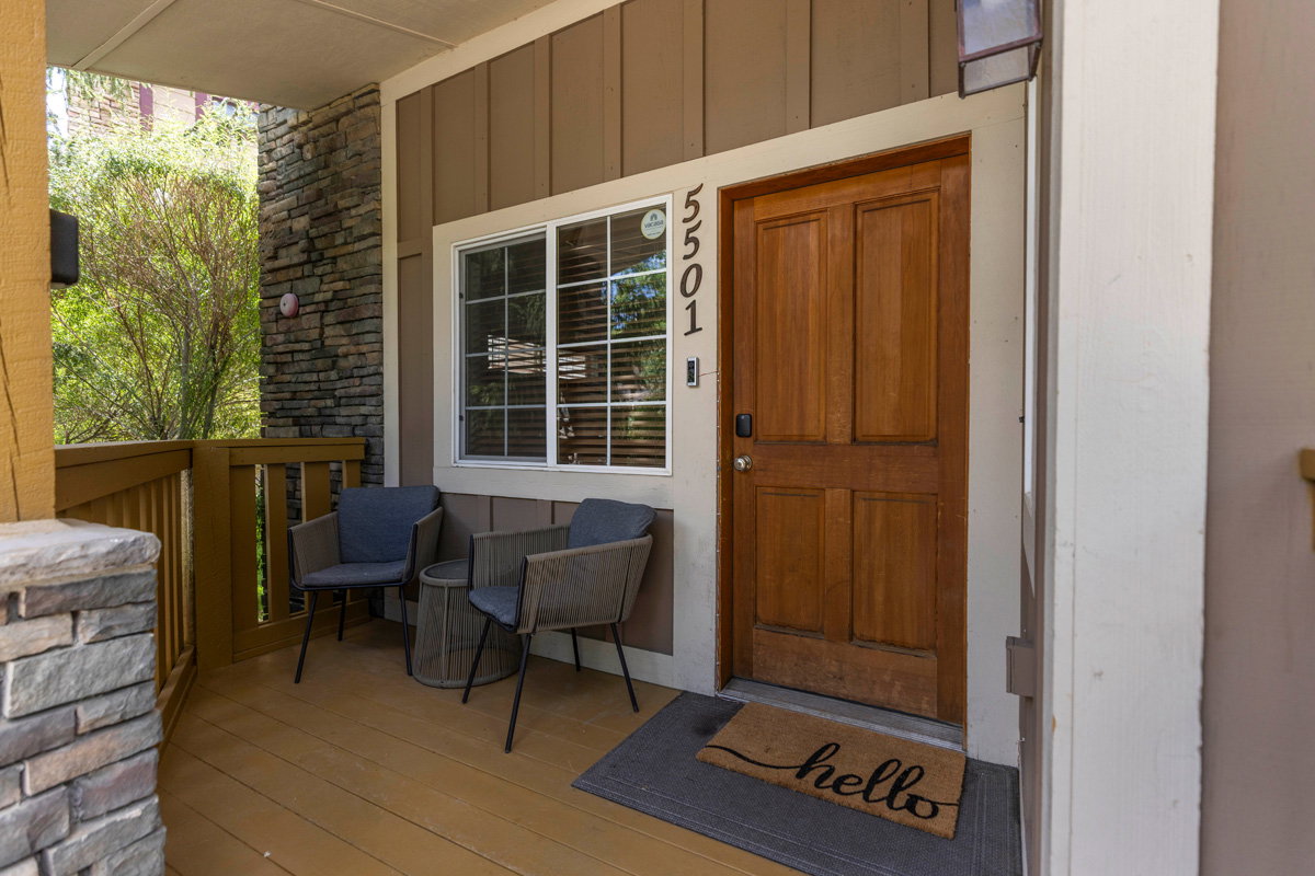 Property entrance with stone siding and board and batten siding
