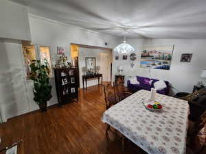 Dining space with dark wood-style floors and a chandelier