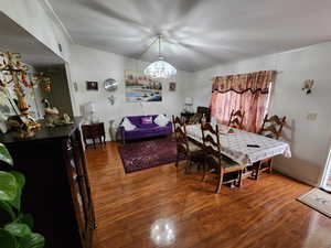 Dining space with wood finished floors and a chandelier