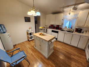 Kitchen with pendant lighting, a chandelier, light wood finished floors, and dishwashing machine