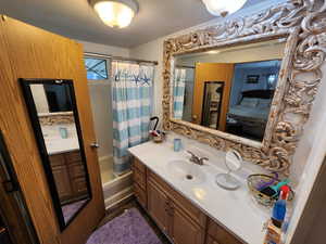 Bathroom featuring shower / tub combo with curtain and vanity