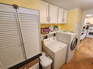 Laundry room with light wood-style floors and washing machine and dryer