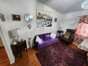 Living area with wood finished floors and vaulted ceiling