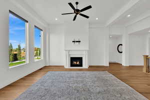 Unfurnished living room with light wood finished floors, a warm lit fireplace, recessed lighting, and a ceiling fan