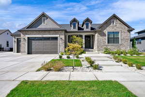Craftsman-style house with driveway, a porch, a garage, and brick siding