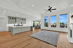 Living room with recessed lighting, a fireplace, light wood-type flooring, and a ceiling fan