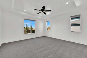 Empty room featuring light colored carpet, a raised ceiling, wooden ceiling, recessed lighting, and ceiling fan