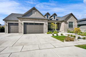 Craftsman inspired home featuring driveway, a garage, covered porch, brick siding, and roof with shingles