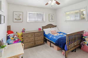 Bedroom with light carpet and a ceiling fan