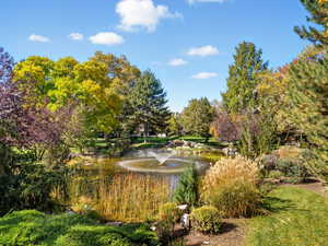 View of property's community with a water view and view of wooded area