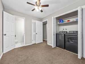 Laundry area featuring light colored carpet, a ceiling fan, and washer and clothes dryer