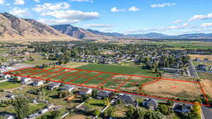 Aerial perspective of suburban area with property parcel outlined and a mountainous background