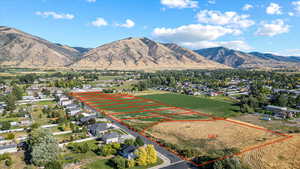 Aerial perspective of suburban area featuring property boundaries highlighted and a mountainous background