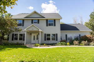 View of front of house featuring roof with shingles and a front lawn