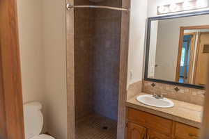 Full bathroom with vanity, a stall shower, and decorative backsplash