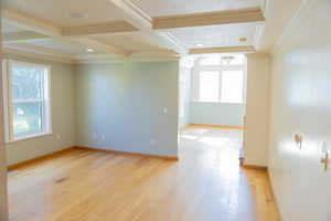 Empty room with light wood-type flooring, ornamental molding, beamed ceiling, coffered ceiling, and recessed lighting