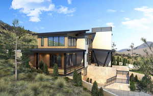 Rear view of property with a mountain view, a gate, and a sunroom