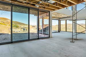 Entryway with a mountain view and unfinished concrete floors