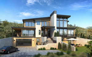 View of front facade featuring stairs, driveway, a balcony, and an attached garage