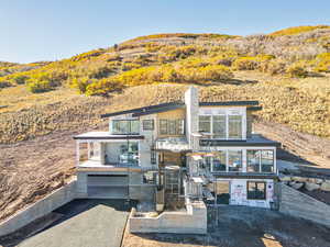 View of front of property featuring driveway, stairway, and an attached garage