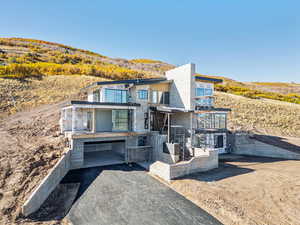 View of front facade with a balcony and stone siding