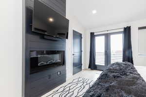 Bedroom with access to outside, recessed lighting, light wood-style floors, vaulted ceiling, and french doors
