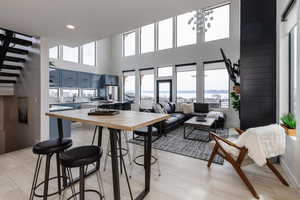 Kitchen featuring blue cabinetry, plenty of natural light, light wood-style flooring, a high ceiling, and recessed lighting
