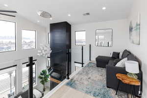 Living room with recessed lighting, wood finished floors, and vaulted ceiling