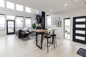 Dining space featuring healthy amount of natural light, light wood-style floors, recessed lighting, and a fireplace